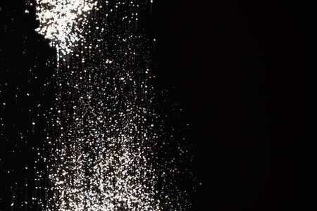 Abstract black and white background of pouring flour, space for text.の写真素材