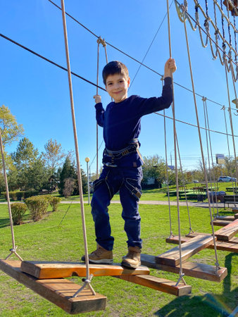 A seven-year-old boy in a kids ropes course adventure park.