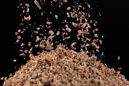 Grated natural organic chocolate shavings on a black background.の写真素材