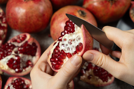 The process of easily opening the pomegranate with a knife, dividing the pomegranate into slicesの写真素材