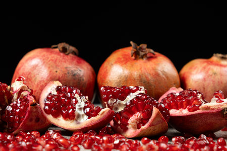 Ripe pomegranates, peeled and whole, the concept of benefits and vitamins in fruitの写真素材