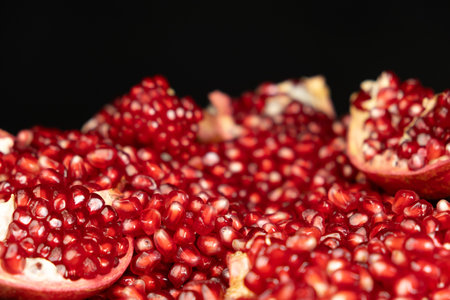 Pomegranate background, lots of peeled pomegranates and seeds, black background.の写真素材