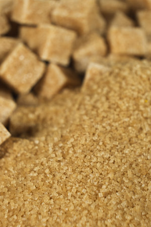 Brown cane unrefined sugar in the form of crystals and cubes.の写真素材