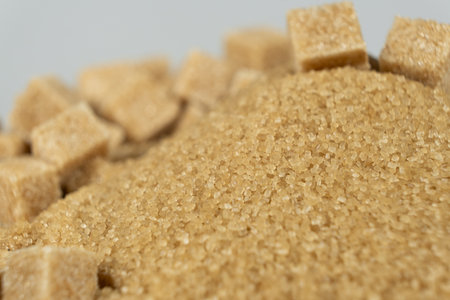 Brown cane unrefined demerara sugar in the form of crystals and cubesの写真素材