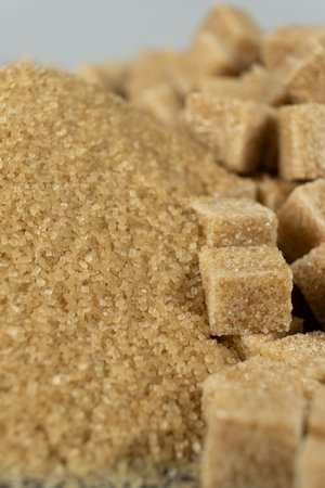 Brown cane unrefined demerara sugar in the form of crystals and cubesの写真素材