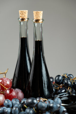 Balsamic vinegar in bottles among grapes.