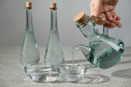White distilled vinegar is poured into a glass vinegar bowl