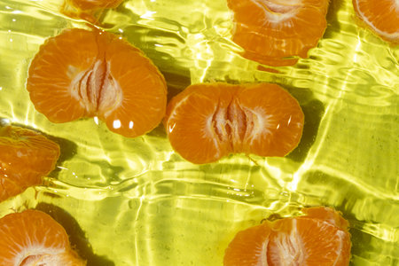 Fresh tangerines splashing into clear water top viewの写真素材