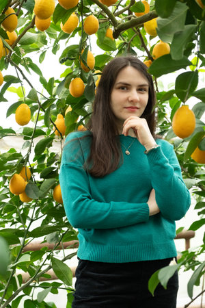Beautiful 30 year old woman in lemon garden. A walk in nature, feminine energy.の写真素材