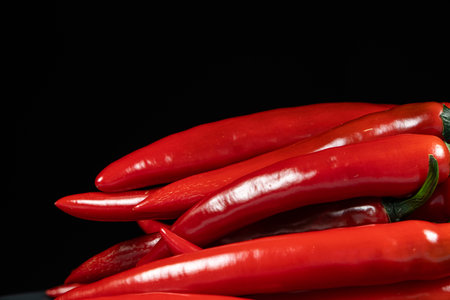 Fresh Red Chili Peppers on Black Background Copy Spaceの写真素材
