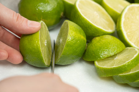 Cutting Fresh Lime in Half with Kitchen Knifeの写真素材