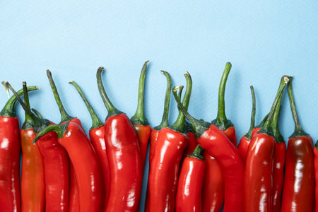 Sharp and Spicy Chili Peppers Top View on Blue Backgroundの写真素材