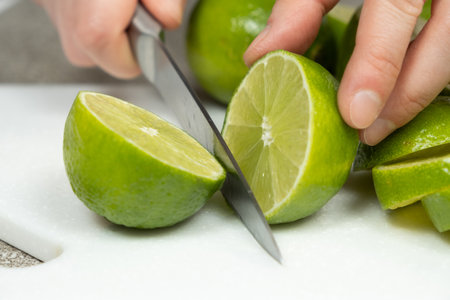 Cutting Fresh Lime in Half with Kitchen Knife.の写真素材
