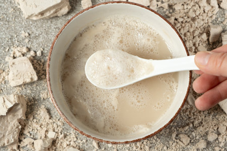 Activation of wet fresh yeast in warm water with sugarの写真素材