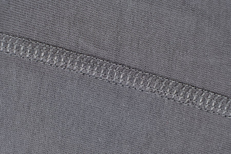 Macro texture of gray fabric consisting of cotton with a slight addition of elastane. Stitching with threads.の写真素材
