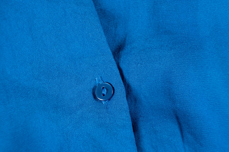 Button on a polyester shirt close-up.の写真素材