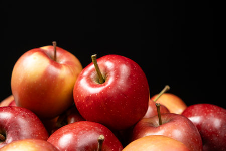 Group of fresh organic red whole apples on a black background.