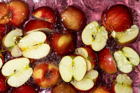 Juicy Whole and Cut Red Apples Close-Up in Water Splash Top View.の写真素材