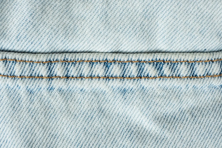 Detailed View of Blue Jeans Fabric and Yellow Thread Stitching.の写真素材