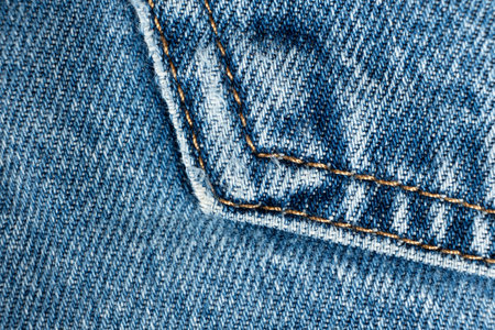 Macro fabric texture of cotton blue jeans. Pocket and thread stitching.の写真素材