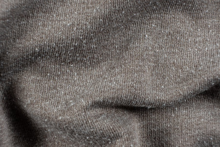Macro texture of gray fabric with lots of pilling and damage on the surface.の写真素材