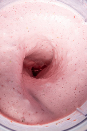 The process of making a strawberry milkshake, whisking all the ingredients in a blenderの写真素材