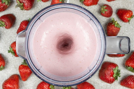 The process of making a strawberry milkshake, whisking all the ingredients in a blenderの写真素材
