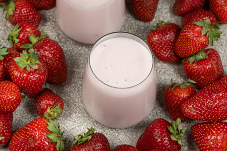 Strawberry Yogurt Served in Glasses Surrounded by Fresh Ripe Strawberriesの写真素材
