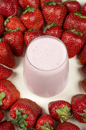 Strawberry sweet milkshake in a glass among fresh ripe strawberriesの写真素材