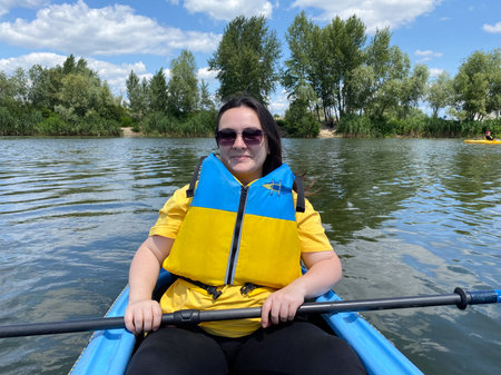 Happy woman in kayak with paddle, summer day, kayaking on the riverの写真素材