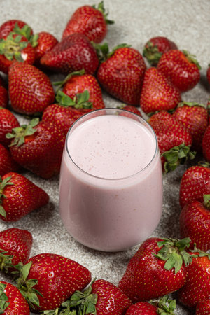 Strawberry milkshake in a glass among fresh ripe strawberriesの写真素材