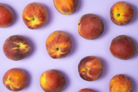 Fruity summer background whole peaches on purple background top view