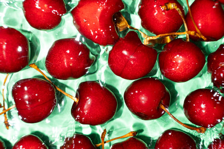 Ripe red sweet cherry in water close-up top view