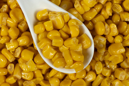 Close-Up Of Sweet Canned Corn Kernels In Spoon