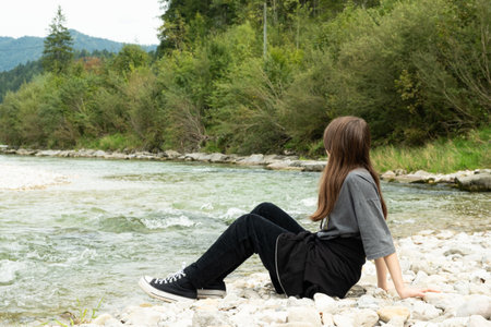 Teen Girl Sitting Along the River in Natureの写真素材