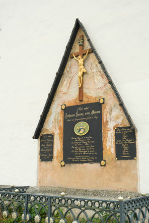 Traditional Austrian Stone Memorial with Crucifix in an Alpine Village. 12 October 2025, Lunz am See, Austriaのeditorial素材