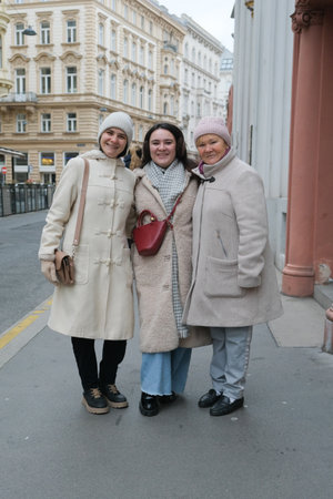 A mother and two adult daughters are walking around the city in winter.の写真素材