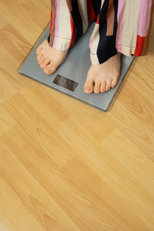Bare Feet Standing on Modern Digital Bathroom Scales for Weighing.
