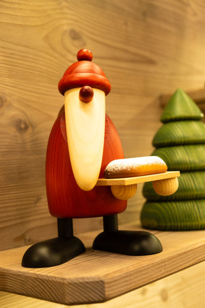 Minimalist Wooden Santa Claus Figurine with Pastry at Christmas Market. December 20, 2025, Vienna, Austria.のeditorial素材