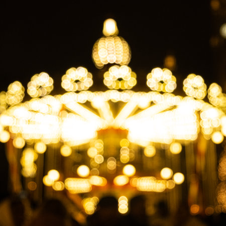 Traditional fairground carousel with glowing light bulbs.の写真素材