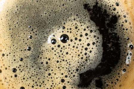Macro texture of golden coffee foam with many small bubblesの写真素材