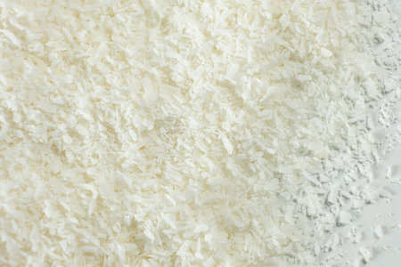 Pile of coconut flakes on white background macro.