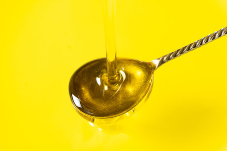 Pouring extra virgin olive oil into silver spoon.の写真素材