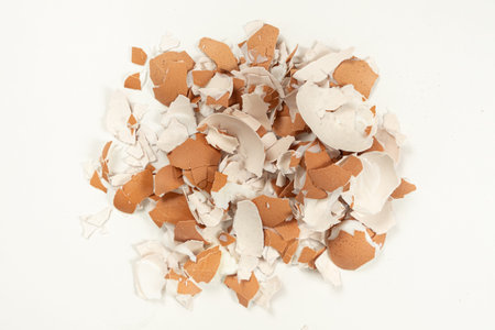 Pile of broken brown eggshell isolated on white background