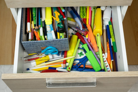 Messy Open Drawer Full of Colorful School Stationery and Pencils.