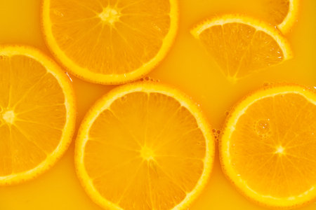 Orange slices swimming in fresh orange juice, horizontal macro