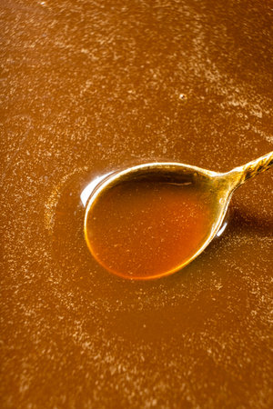 Salted caramel sauce in metal spoon close upの写真素材
