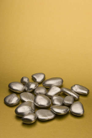 Silver painted stones set against a gold background.の写真素材