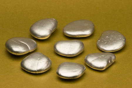 Silver painted stones set against a gold background.の写真素材