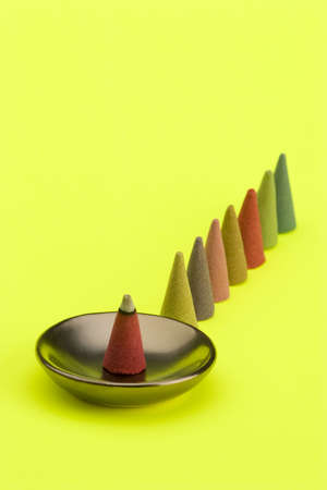 Multi coloured Incense cones against a bright coloured background.の写真素材